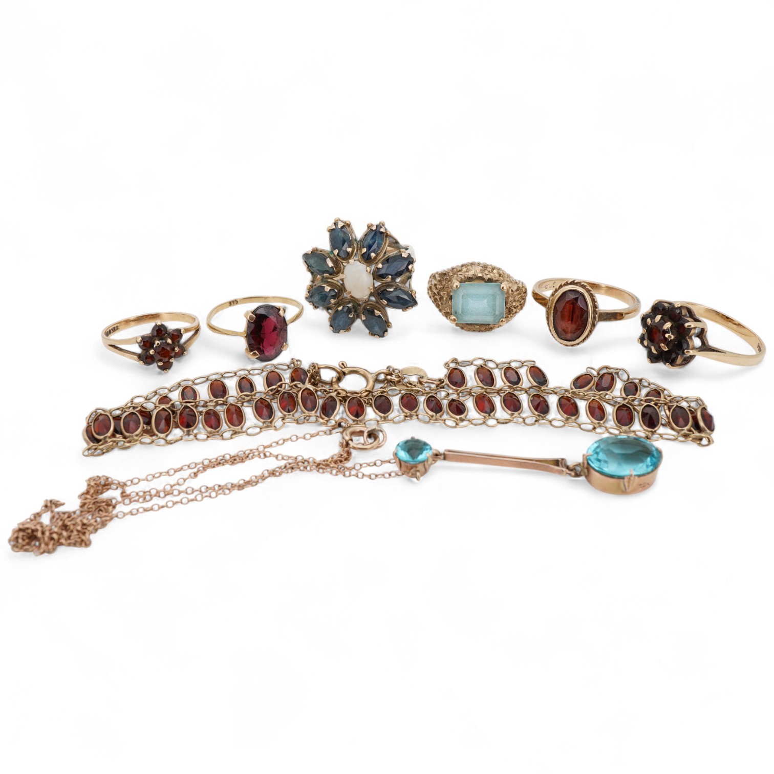 A group of jewels, comprising: two garnet cluster rings; a garnet bracelet; and a blue topaz ring, each mounted in 9ct gold, ring sizes H-M1/2, combined gross weight 13 grams; together with a marquise-shaped sapphire and